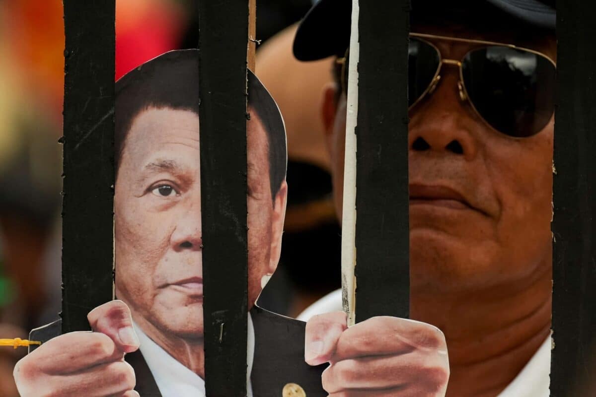 PHOTO: Supporter with placard of Rodrigo Duterte behind bards FOR STORY: EXPLAINER: Can jailed Duterte be Davao City mayor? Here’s what DILG says
